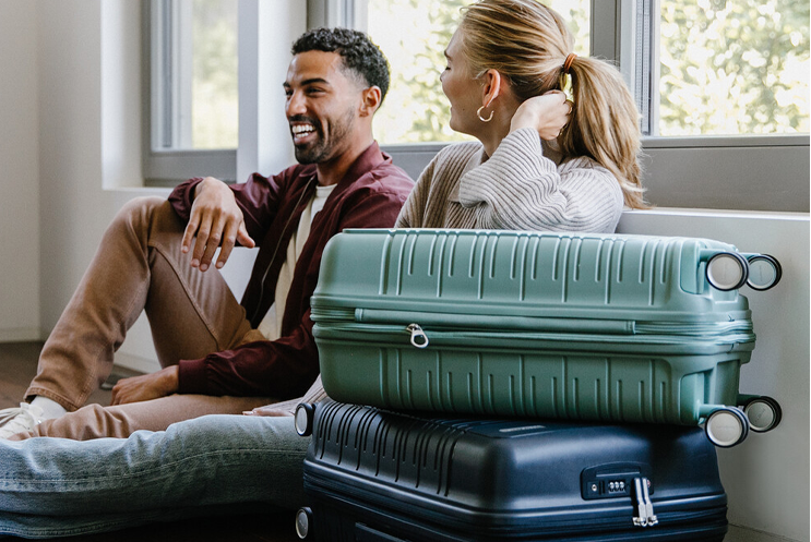 Couple with suitcases, sitting on the floor